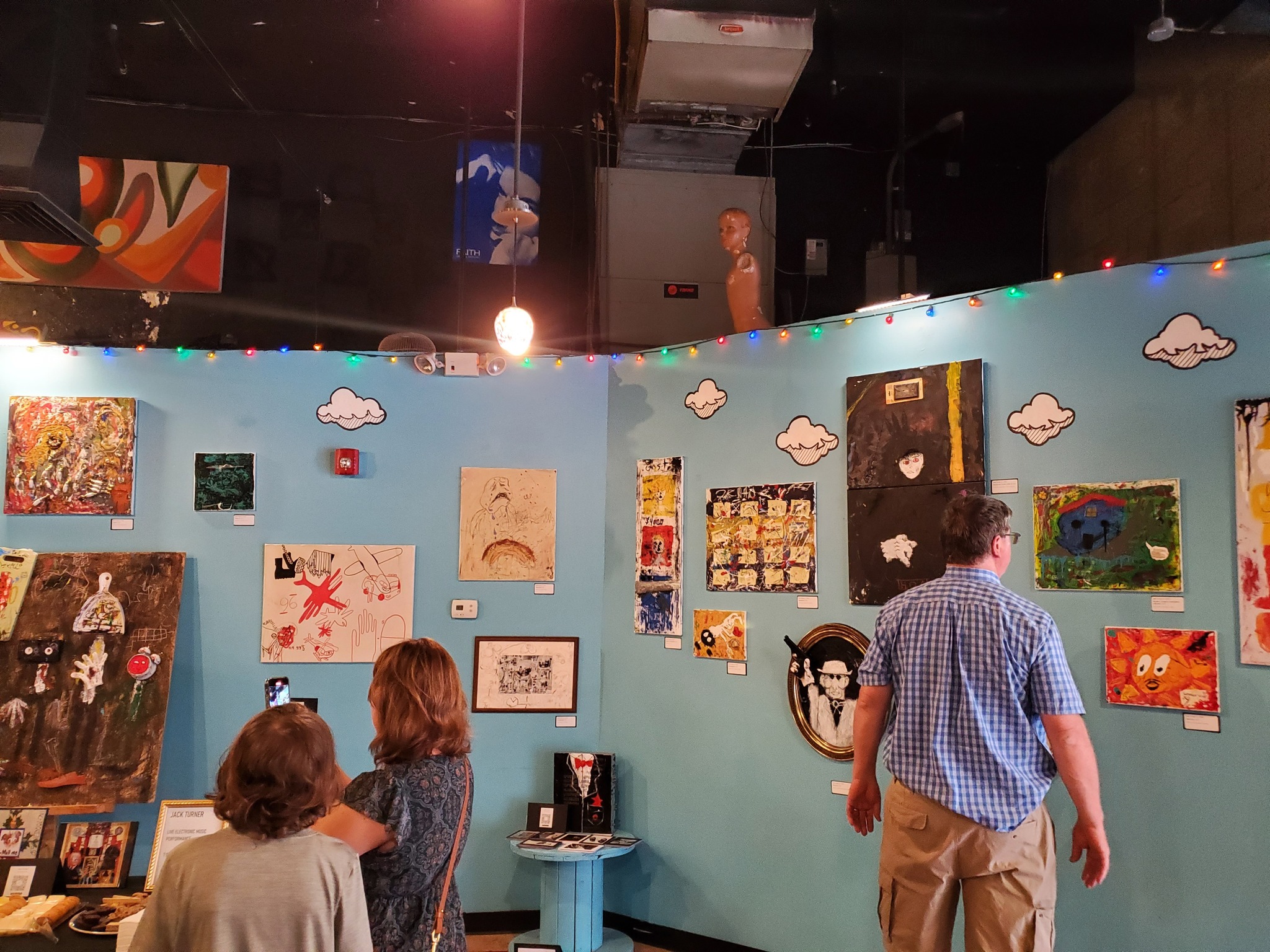 Visitors browsing the gallery wall