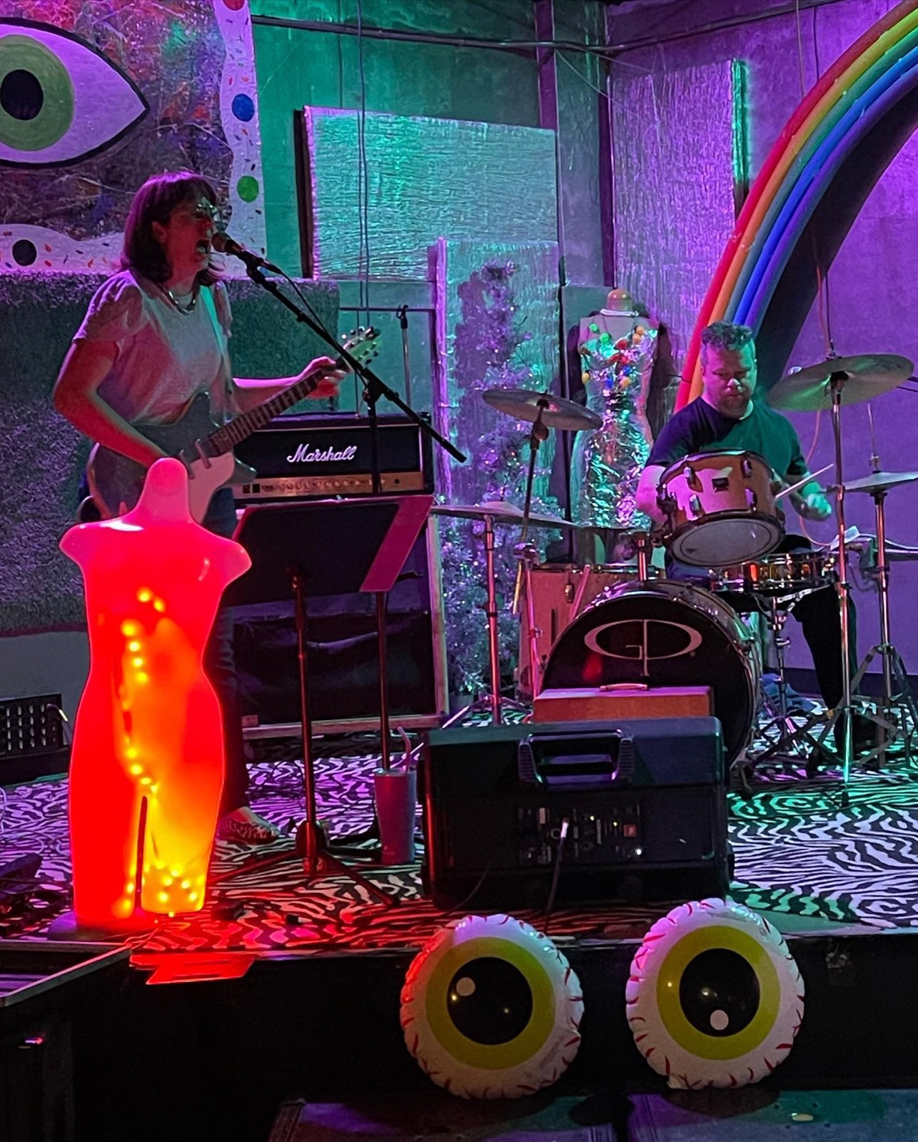Band playing under the rainbow with the glowing eyeball stage